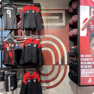 FC Bayern München Fanshop Wandgestaltung – Adidas-Markenmotive und Trikots vor bedruckter Wand