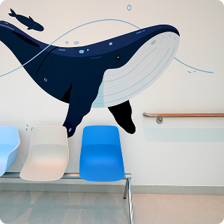 Wanddruck Kinderklinik Bethel – großformatiger Blauwal auf weißer Klinkwand im Wartebereich