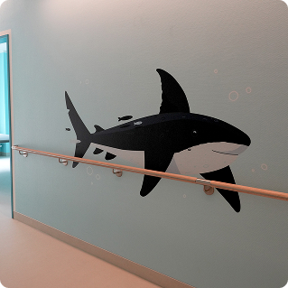 Wanddruck Kinderklinik Bethel Flur – Orca-Motiv auf blauer Wand neben Handlauf