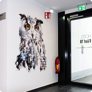Wanddruck im Hotel fünf10 – großformatiger Eulenmotiv-Wanddruck im Hotelflur auf Putz