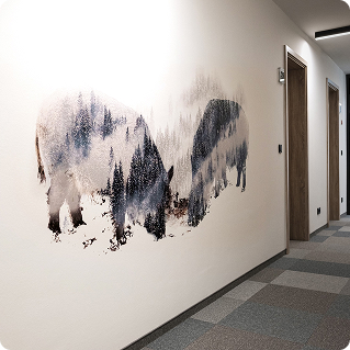 Hotelflur Hotel fünf10 – Gesamtansicht mit Bison-Wanddruck auf weißer Wand und Zimmertüren