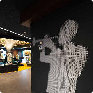 Wandgestaltung Thomann Musikgeschäft – pixeliger Musikersilhouette-Wanddruck in der Instrumentenabteilung
